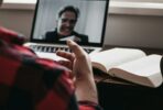 person in red and black plaid long sleeve shirt using black laptop computer