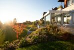 a house with a large lawn and flowers in front of it